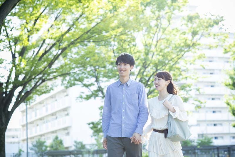 手をつないで歩いている男女