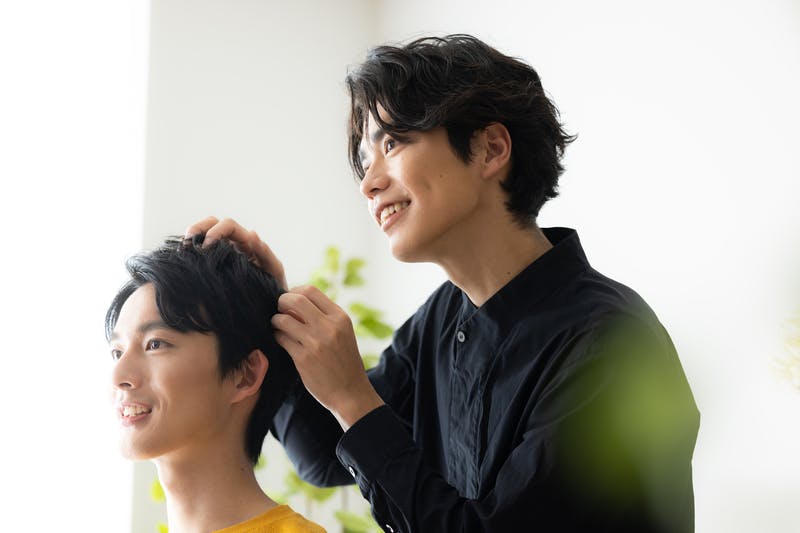 おでこをオープンにした髪型に仕上げるヘアスタイリスト