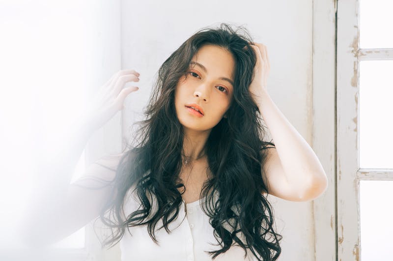 ウェービーロングヘアのアンニュイな雰囲気の若い女性