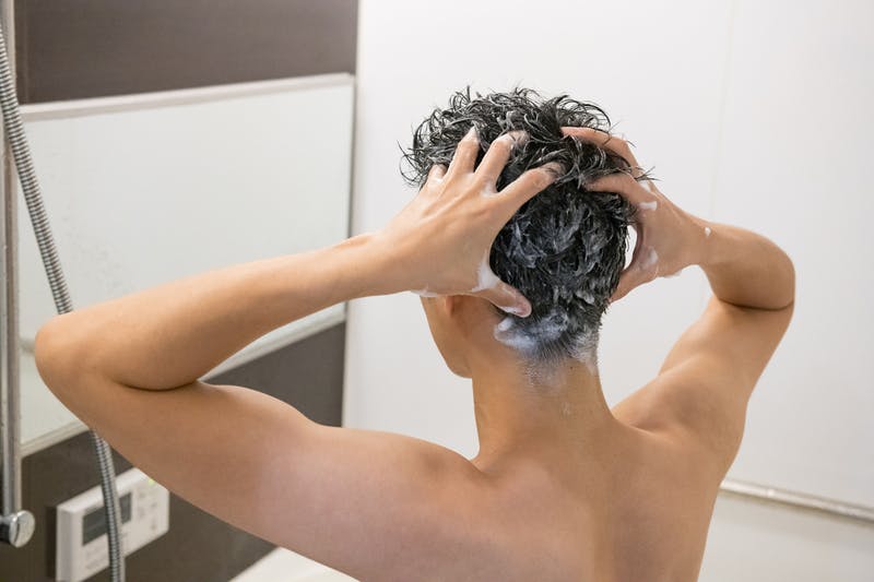 シャンプーで洗髪する男性の後ろ姿