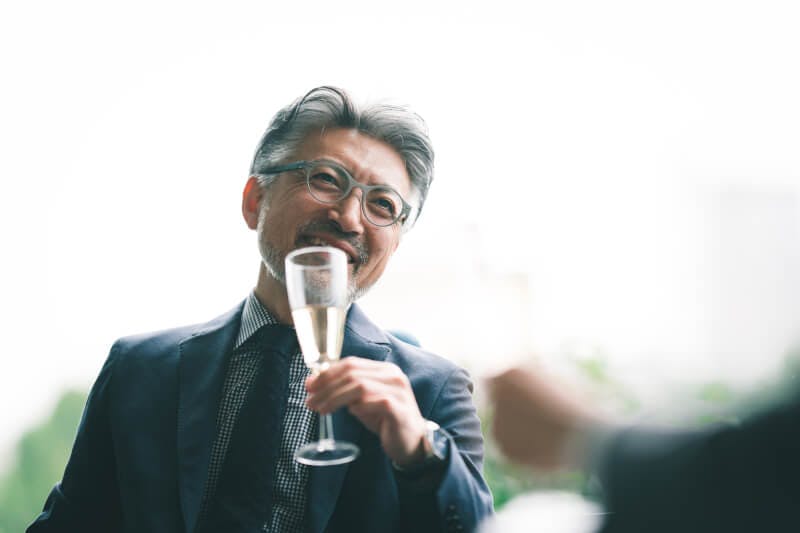ラウンジでシャンパンを飲むシニア層の男性