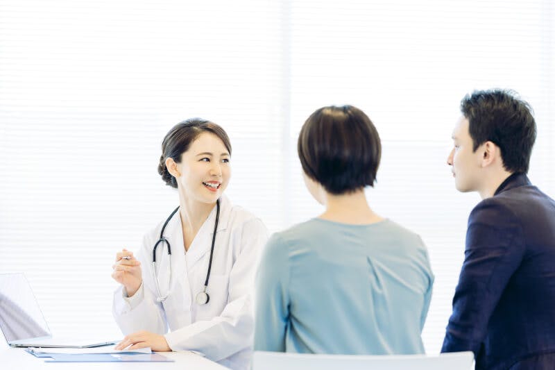 クリニックで女性医師による問診を受けるカップル02