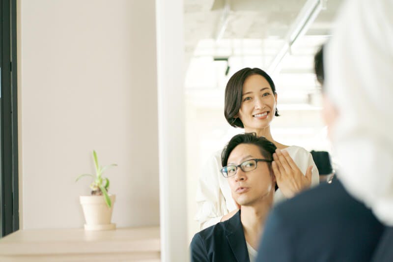 鏡越しに映る美容師と男性客