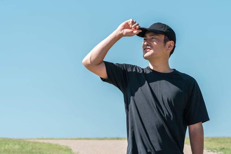 青空の下にいるスポーツウェア姿の男性