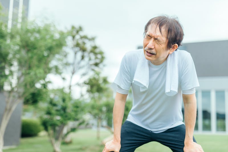 膝に手をつきバテている男性