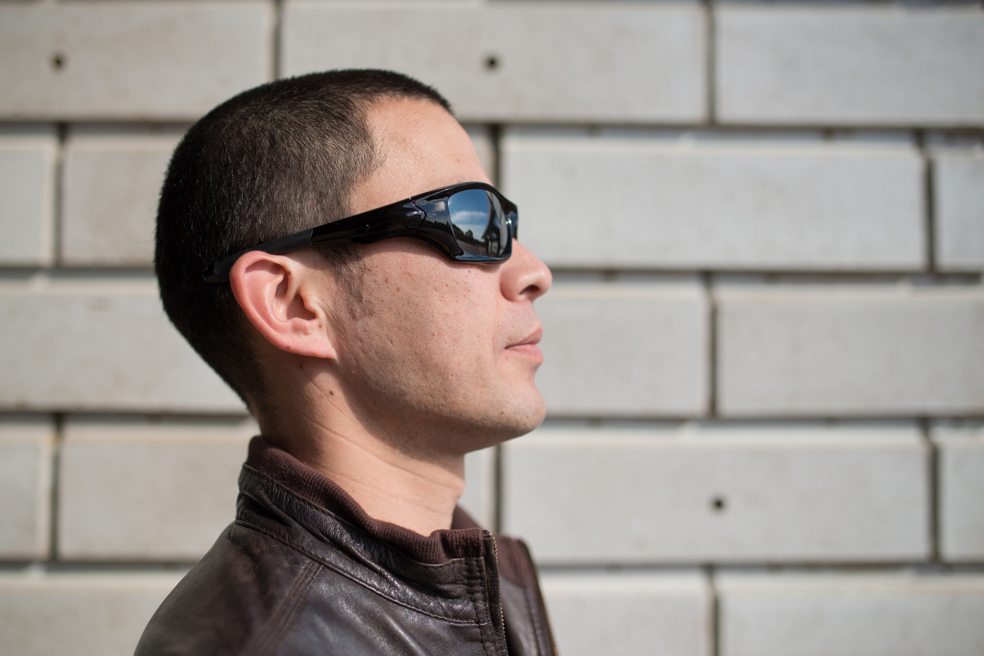 サングラスをかけて坊主スタイルをおしゃれに仕上げた男性