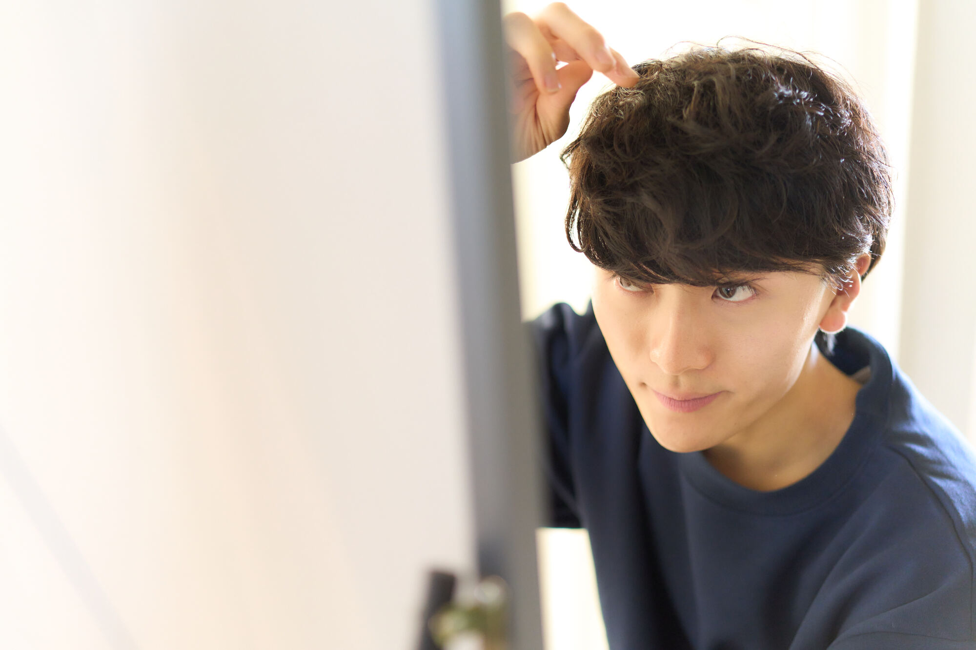 サイドや襟足のボリューム感を抑えたマッシュヘアスタイルの男性