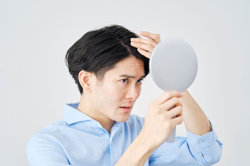 ハンドミラーで前髪をチェックしているところ