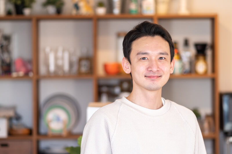 カメラ目線で笑顔を見せる男性