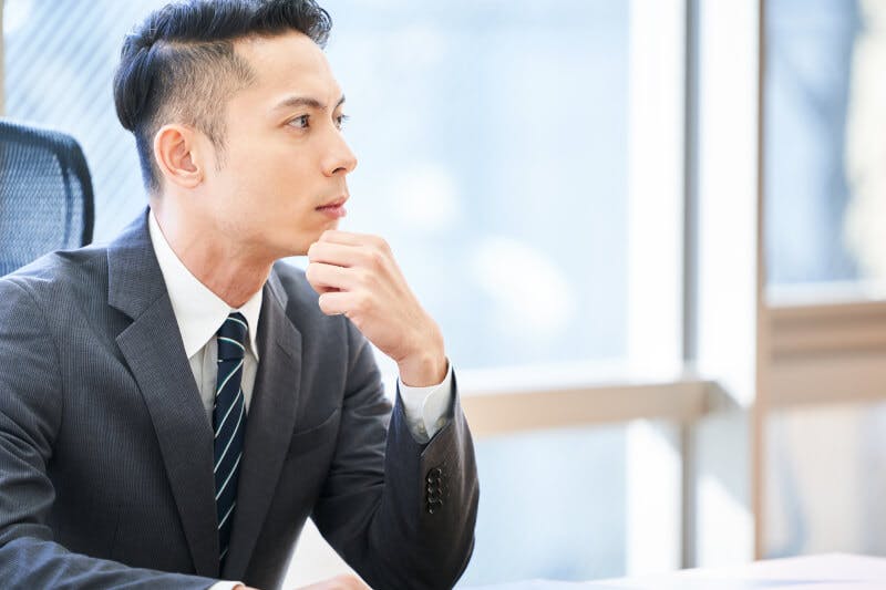 デスクに座っているツーブロックの男性