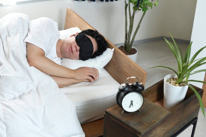 アイマスクをしながら眠る男性