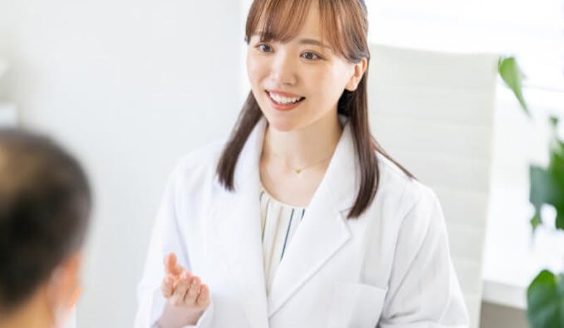薄毛の男性から相談を受ける女性カウンセラー